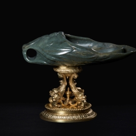 Vaso de jade en forma de mascarón, sobre cuatro delfines