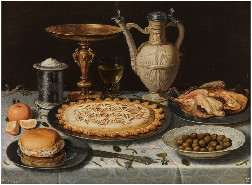 Mesa con mantel, salero, taza dorada, pastel, jarra, plato de porcelana con aceitunas y aves asadas