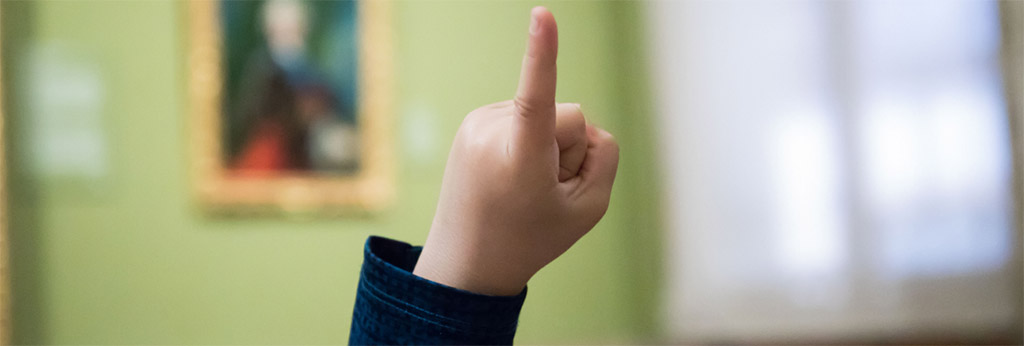 Un ni&ntilde;o levanta la mano (detalle del dedo)